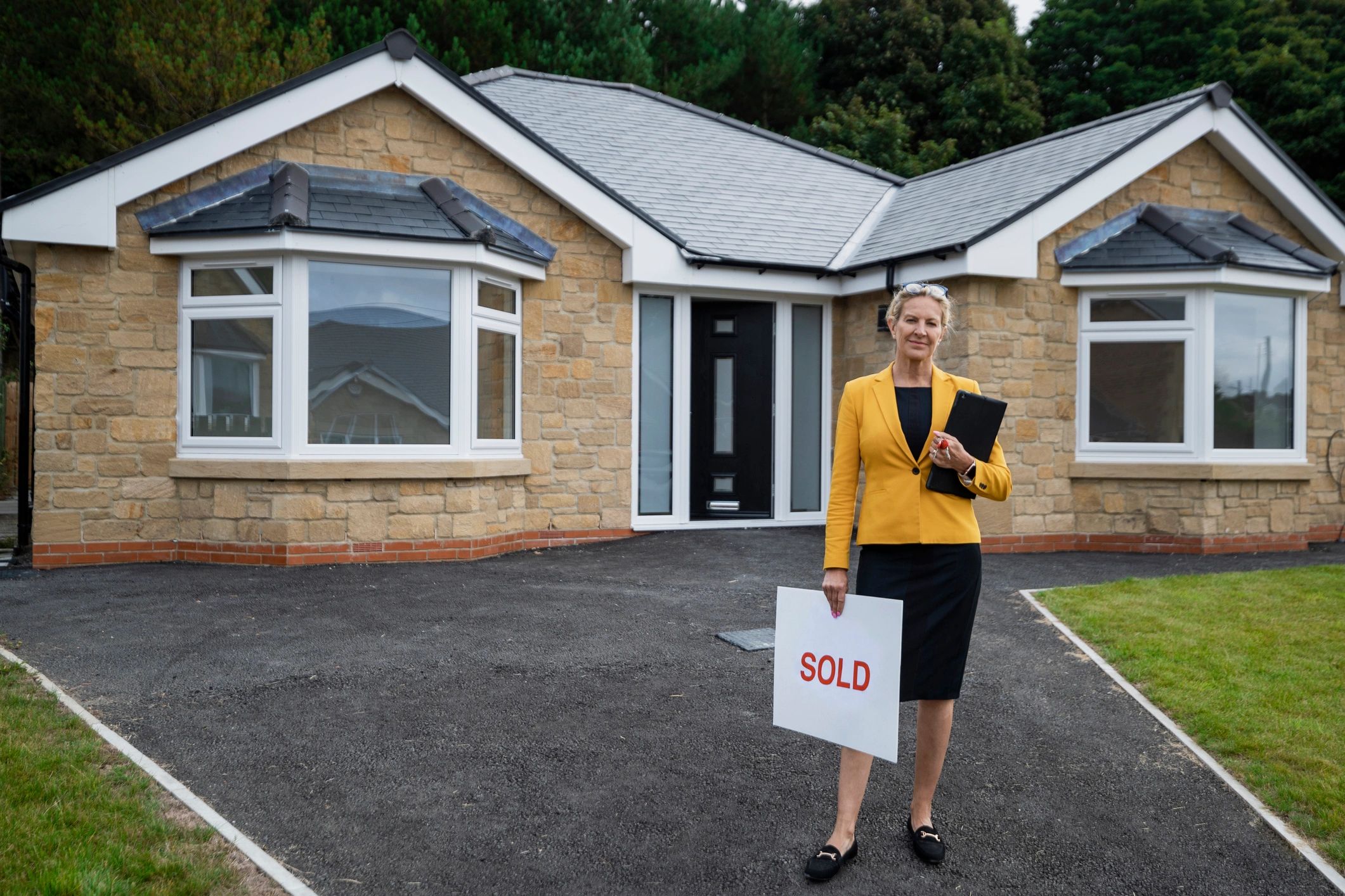 Real estate agent standing outside a sold property